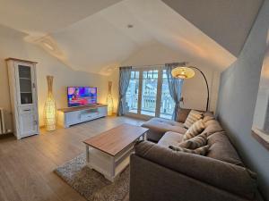 ein Wohnzimmer mit einer Couch und einem Tisch in der Unterkunft Dünenpark Binz - Klassik Ferienwohnung mit 1 Schlafzimmer und Balkon im Dachgeschoss 184 in Binz