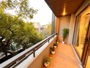 an outdoor balcony with potted plants and a window at Hotel South Ex Residency - South Ex near AIIMS Delhi - Couple Friendly in New Delhi
