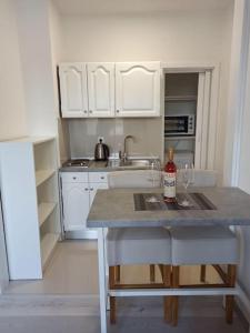 una cocina con armarios blancos y una mesa con 2 copas de vino en Apartment IVA, en Čitluk