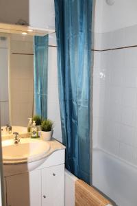 a bathroom with a sink and a blue shower curtain at Résidence Les Chaumettes - 2 Pièces pour 6 Personnes MAE-8964 in Le Dévoluy