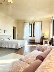 ein großes Schlafzimmer mit 2 Betten und einem Sofa in der Unterkunft Agriturismo Villa Di Campolungo in Fiesole