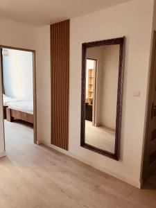 a mirror on a wall in a room with a bed at Apartament na Rynku in Wągrowiec