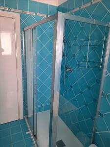 y baño con ducha y azulejos azules. en Fiori del Conero en Ancona