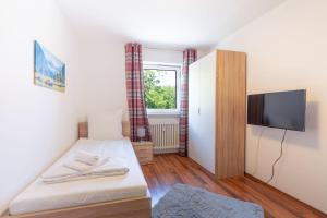 a small room with a bed and a flat screen tv at Allgäu-Heimat in Sonthofen