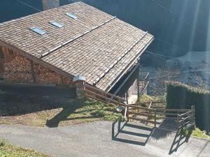 ein kleines Haus mit einem Dach und einer Bank in der Unterkunft Savoie, Simple mais confortable in Villard-sur-Doron