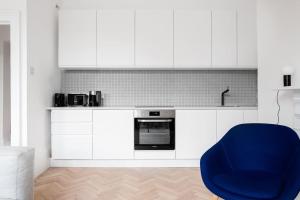 a kitchen with white cabinets and a blue chair at Spacious Georgian Pad - Free Parking - Walk to Bath in Bath
