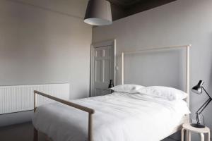 a white bedroom with a large bed with white sheets at Spacious Georgian Pad - Free Parking - Walk to Bath in Bath