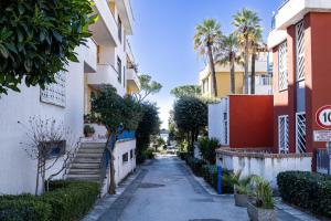 uma rua numa cidade com palmeiras e edifícios em RUA DE MAR PORTICI em Portici