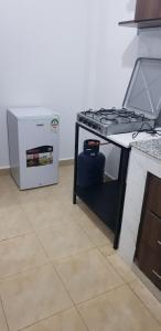 a stove top oven in a kitchen next to a refrigerator at Saas Homestay in Eldoret