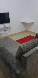 a living room with a couch and a television at Saas Homestay in Eldoret