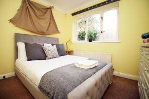 a bedroom with a bed and two windows at Chartwell Grove (Spacious 7 BR with FREE parking) in Nottingham