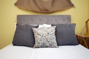 a bed with a bunch of pillows on it at Chartwell Grove (Spacious 7 BR with FREE parking) in Nottingham