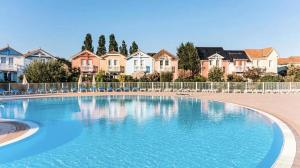 a large swimming pool in front of some houses at Les Maisons de Port Bourgenay - maeva Home - Maison 3 pièces 6 personnes - Sélection MAE-6402 in Talmont