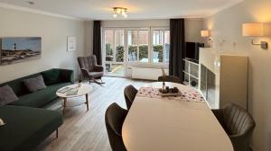 a living room with a couch and a table at Blumeninsel in Horumersiel