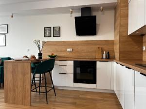 cocina con armarios blancos y encimera con mesa en Apartament Letnica Latarników Family Seaside, en Gdansk