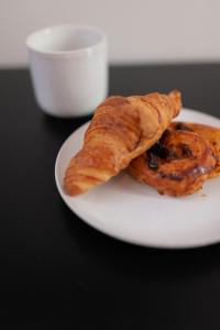 a white plate with two pastries on a table at Tinah Paris, Aboukir in Paris