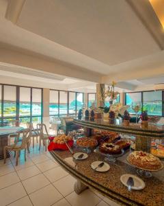 une salle avec un buffet de nourriture sur une table dans l'établissement Morro do Sol Hotel & Eventos, à Porto Belo