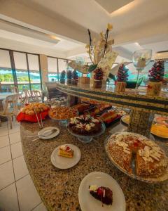 um buffet com muitos tipos diferentes de comida em um balcão em Morro do Sol Hotel & Eventos em Porto Belo