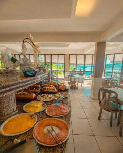 a buffet in a resort with plates of food at Morro do Sol Hotel & Eventos in Porto Belo
