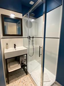 a bathroom with a shower and a sink at Les Appartements du Grand Hôtel Clichy Paris in Clichy