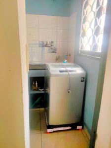 a small refrigerator in a kitchen with a window at Good stay service apartments cenotaph road in Chennai