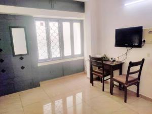 a living room with a table and chairs and a television at Good stay service apartments cenotaph road in Chennai