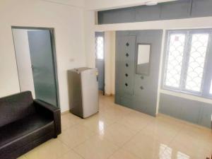 a living room with a refrigerator and a window at Good stay service apartments cenotaph road in Chennai