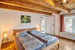 2 bedden in een slaapkamer met houten plafonds bij Ferienhaus Felicia OG in Ravensburg