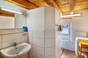 Un baño blanco con lavabo y espejo. en Ferienhaus Felicia OG, en Ravensburg 14 fotos más