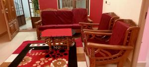 a living room with two chairs and a rug at AVAR Home syay in Virāmpattinam