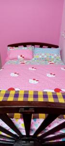a bed in a bedroom with a pink wall at AVAR Home syay in Virāmpattinam