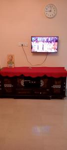 a living room with a television and a red table at AVAR Home syay in Virāmpattinam