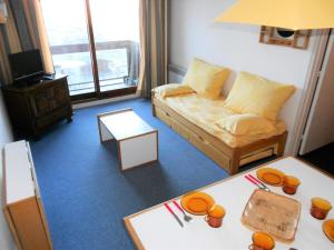 una sala de estar con un sofá y una mesa en Résidence Phenix - STUDIO CABINE 4/5 PERSONNES MAE-9844, en Le Corbier