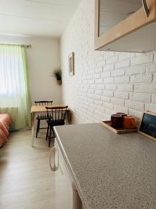 cocina y comedor con pared de ladrillo blanco en 5 minute walk to LEGO house - best location-garden on site-n18, en Billund