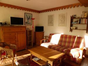 sala de estar con sofá y mesa en Résidence La Cordee - 3 Pièces pour 6 Personnes 224, en Les Contamines-Montjoie