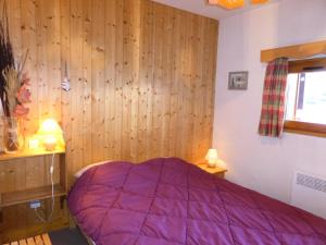 1 dormitorio con cama morada y paredes de madera en Résidence La Cordee - 3 Pièces pour 6 Personnes 224, en Les Contamines-Montjoie