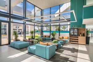 a lobby with blue furniture and large windows at Occidental Mar Menor in Cartagena