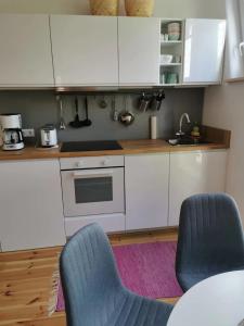 a kitchen with white cabinets and two blue chairs at Ferienwohnung in Anni's Ferienhaus 