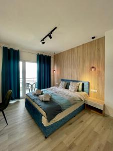 Schlafzimmer mit einem großen Bett und blauen Vorhängen in der Unterkunft Villa Radozda in Struga