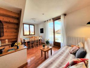 uma sala de estar com um sofá e uma mesa em Résidence Le Hameau Du Puy - Chalets pour 6 Personnes 234 em Le Dévoluy