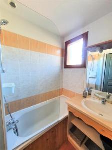 uma casa de banho com uma banheira e um lavatório em Résidence Le Hameau Du Puy - Chalets pour 6 Personnes 234 em Le Dévoluy