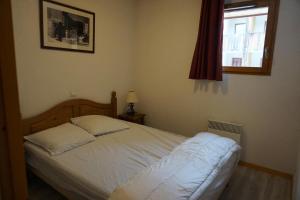 une chambre avec un lit blanc avec une fenêtre dans l'établissement Résidence Cristallines - 3 pièces 6 personnes MAE-4424, à Orcières