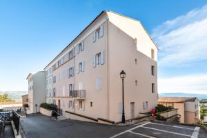 a large white building with a street light in a parking lot at Les Coteaux de Pont Royal en Provence - maeva Home - Appartement 2 Pièces 6 Personnes - Sélection MAE-8180 in Mallemort