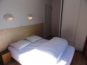 łóżko w pokoju z 2 poduszkami w obiekcie Résidence Les Balcons De La Vanoise - 4 Pièces pour 10 Personnes 004 w mieście Villarodin-Bourget