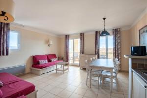 - un salon avec un canapé rouge et une table dans l'établissement Les Coteaux de Pont Royal en Provence - maeva Home - Appartement 3 Pièces 6 81, à Mallemort