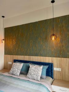 um quarto com uma cama azul com um quadro na parede em Villa Radozda em Struga