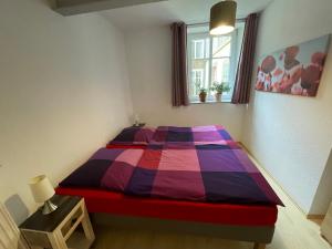 a bedroom with a colorful bed and a window at Ferienwohnung Südliche Weinstraße zwischen Wald und Reben in Klingenmünster