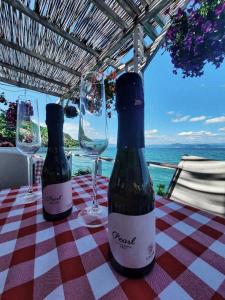 dwie butelki wina siedzące na stole z kieliszkami w obiekcie Villa Radozda w mieście Struga