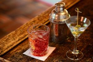 einen Drink im Glas neben einer Flasche auf dem Tisch in der Unterkunft Hotel zur Post in Goldegg