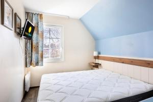 ein Bett in einem Zimmer mit Fenster in der Unterkunft Les Maisons de Belle Dune - maeva Home - Maison 4 Pièces 8 Personnes - Sélection MAE-8187 in Fort-Mahon-Plage + 11 Fotos